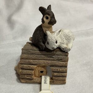 Tiny 3 rabbits 🐇 on a log statue